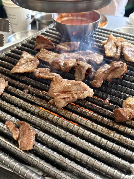 그릴 위에서 익고 있는 다양한 부위의 돼지고기
