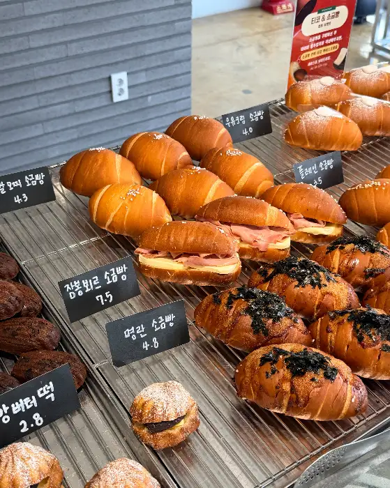 다양한 종류의 소금빵과 샌드위치가 진열된 모습