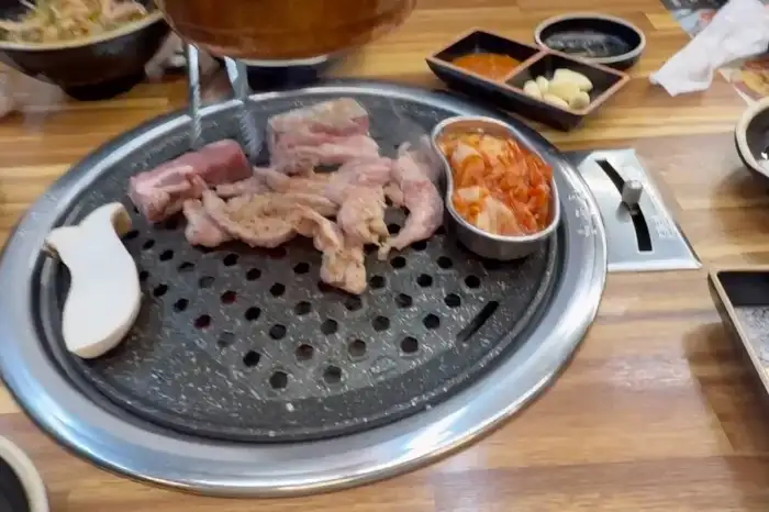 불판 위에 올려진 생고기와 곁들임용 버섯