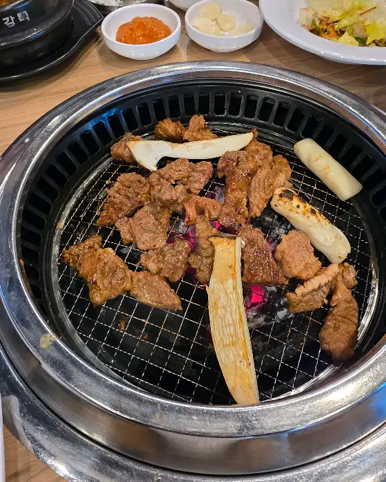 솔가숯불갈비 보령대천점 숯불 위에 올라간 갈비와 곁들임 메뉴
