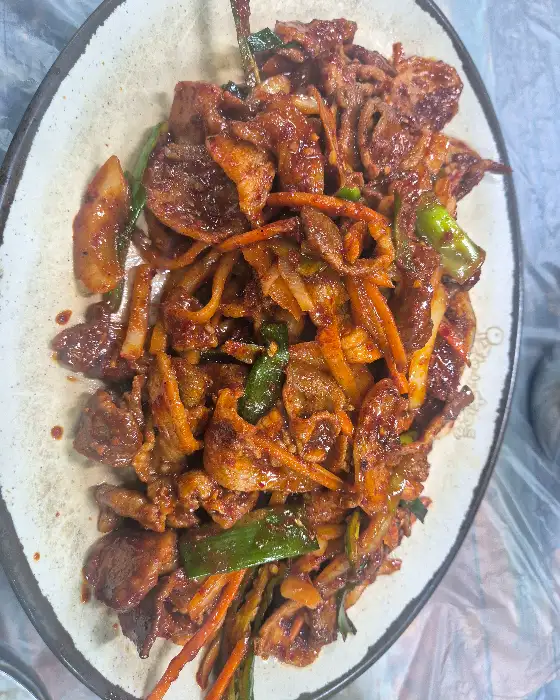 접시에 담긴 제육볶음을 확대 촬영한 모습. 고기와 야채가 잘 버무려져 있다.
