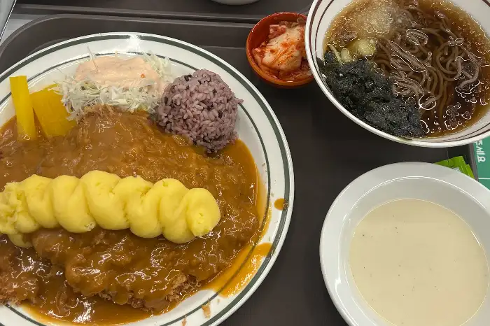 왕돈까스와 쫄면, 그리고 스프가 함께 나온 구성. 푸짐한 양과 다채로운 메뉴가 돋보인다.