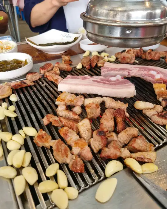 그릴 위에서 구워지고 있는 삼겹살과 마늘