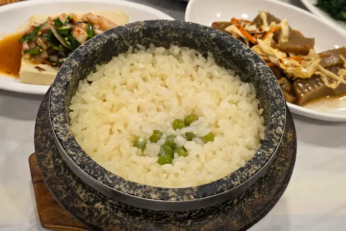 돌솥밥 위에 완두콩이 올려져 있는 모습