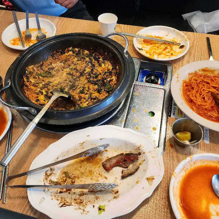 테이블 위에 놓인 다양한 메뉴와 식사 중인 사람들