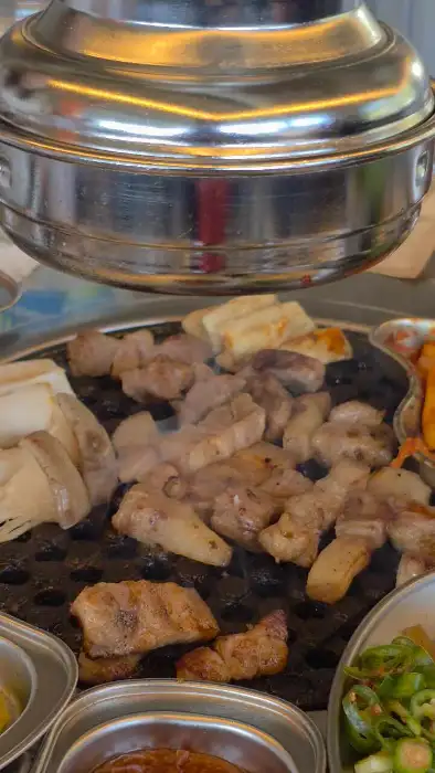 정갈하게 차려진 밑반찬과 함께 구워지는 오겹살