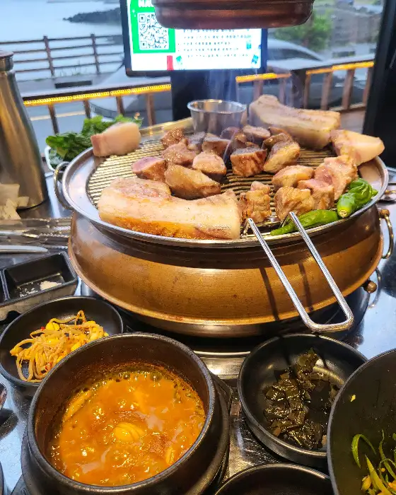 준비된 흑돼지 구이와 함께 제공되는 다양한 밑반찬과 찌개