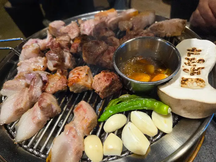 잘 구워진 흑돼지와 함께 곁들여지는 마늘과 고추