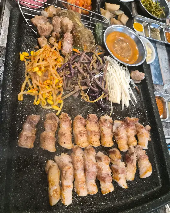 잘 익은 고기 한 점과 쌈채소, 곁들임 찬