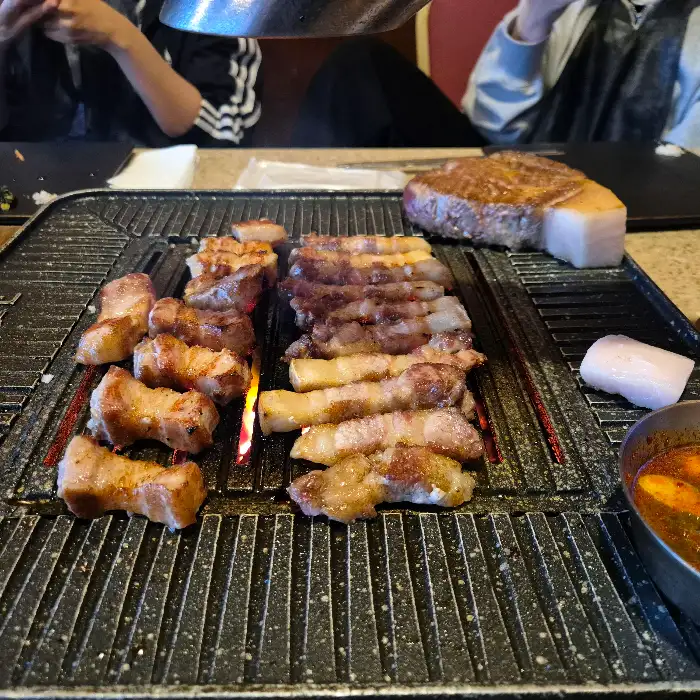 두 종류의 흑돼지가 불판 위에서 익어가고 있습니다.