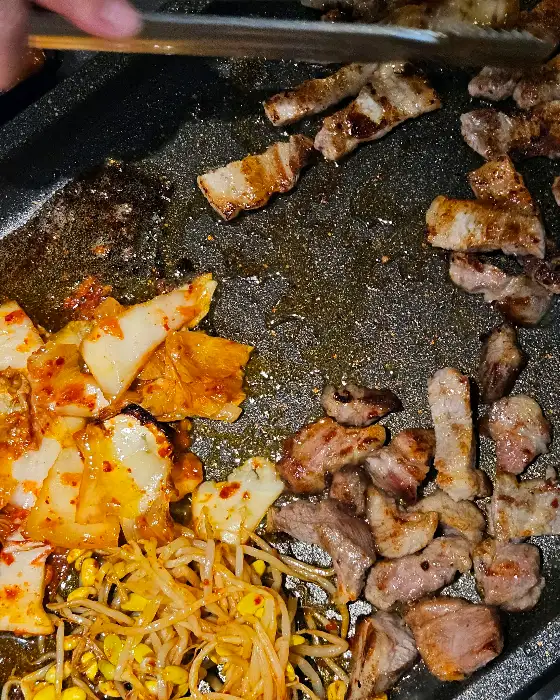 맛있게 구워지고 있는 냉삼과 김치, 콩나물