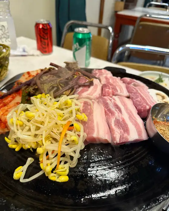 불판 위에 올라가 있는 삼겹살 덩어리들. 지방과 살코기의 비율이 적절해 보인다.
