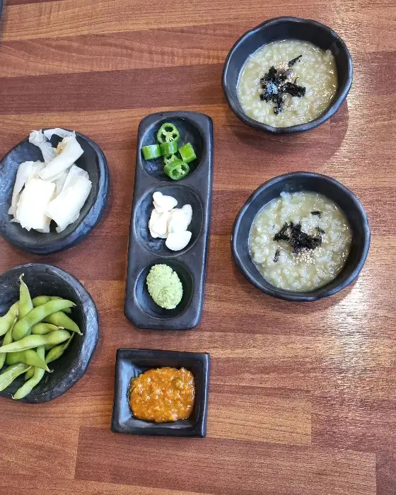 테이블 위에 놓인 따뜻한 전복죽 한 그릇