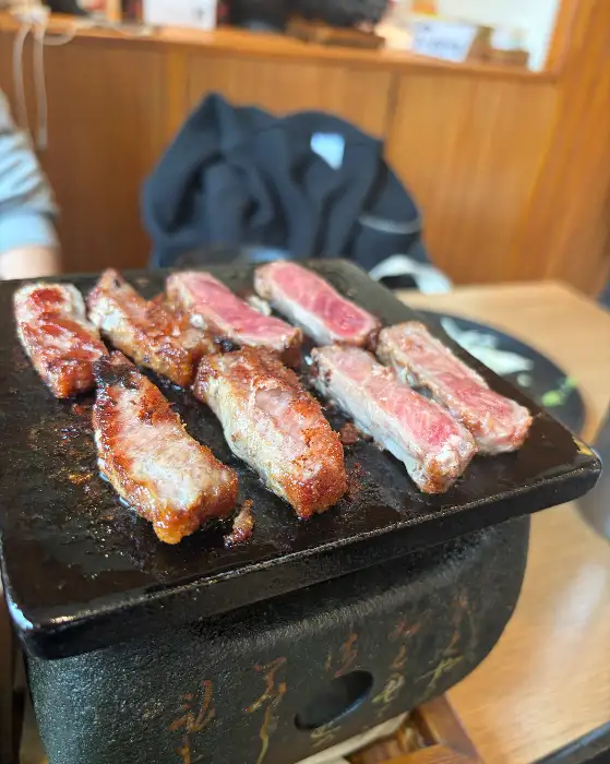 작은 화로 위에서 규카츠 조각들이 맛있게 익어가고 있습니다.