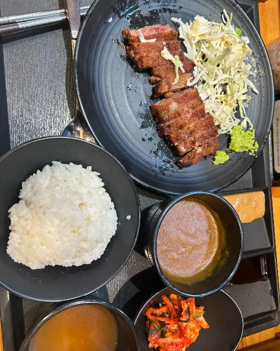 규카츠 조각과 샐러드, 그리고 밥이 함께 담긴 접시입니다.