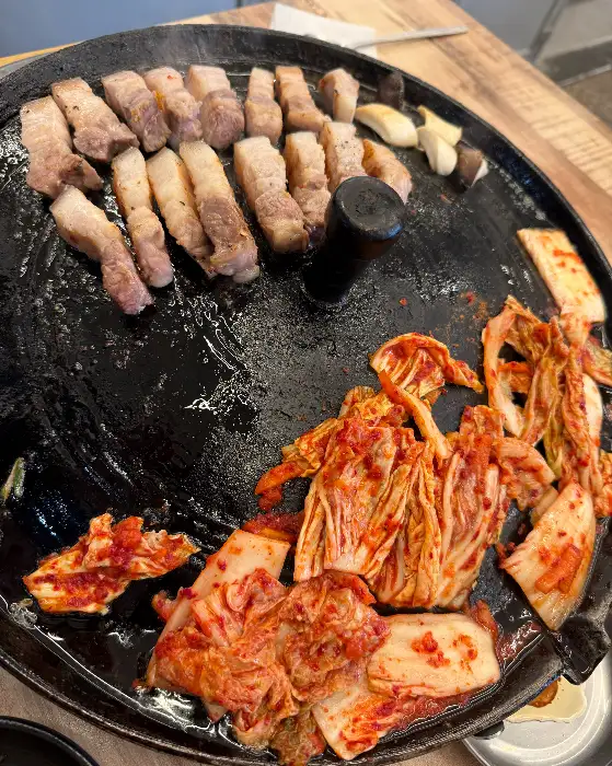 솥뚜껑 위에서 맛있게 구워지고 있는 삼겹살