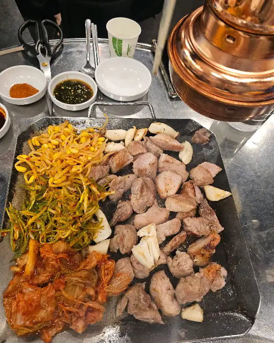 고기와 함께 불판에 올라간 김치, 콩나물, 마늘 등의 모습