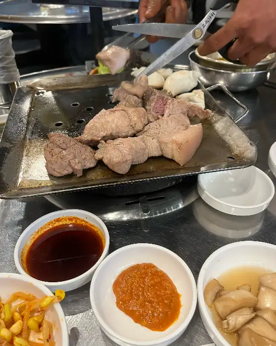 직원이 가위로 뒷고기를 자르고 있는 모습