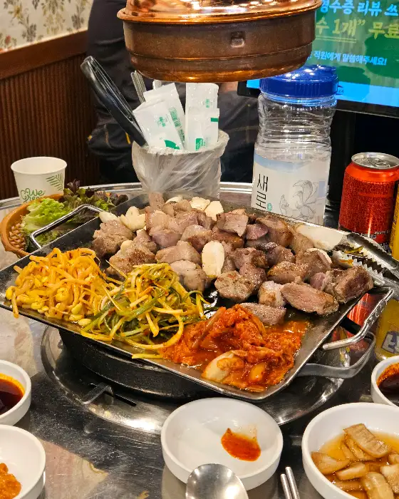 치즈김치볶음밥과 물병, 캔음료가 함께 놓인 테이블 모습