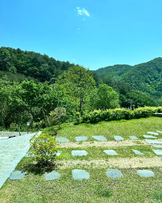 창밖으로 보이는 푸른 잔디와 산 풍경