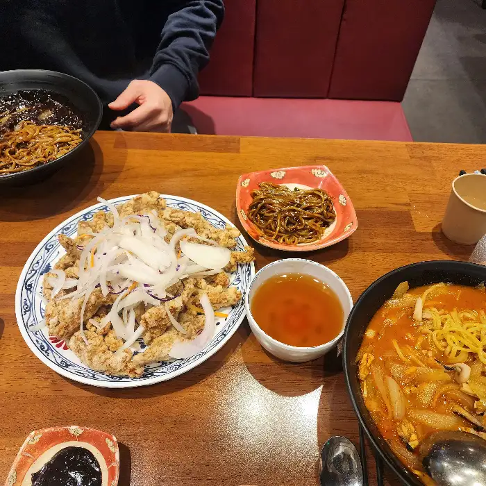 테이블에 놓인 여러 중식 요리들, 탕수육, 짬뽕, 짜장면 등이 보인다.