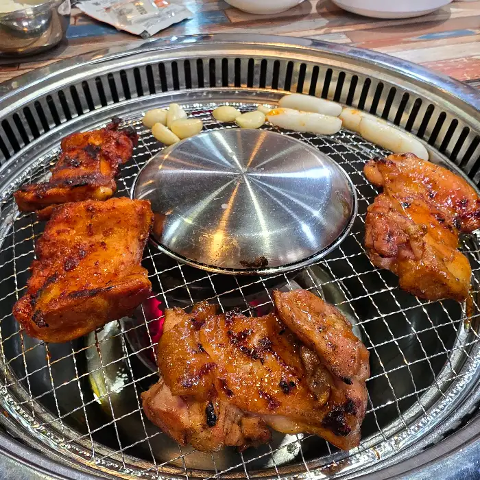 숯불 위에서 익고 있는 닭갈비 조각들