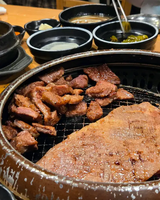 숯불 위에서 구워지고 있는 돼지갈비 조각들