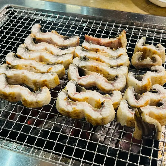 숯불 위에서 노릇하게 구워지고 있는 장어의 모습