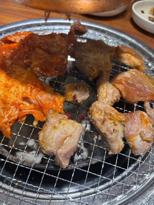 숯불 위에서 익고 있는 다양한 부위의 고기