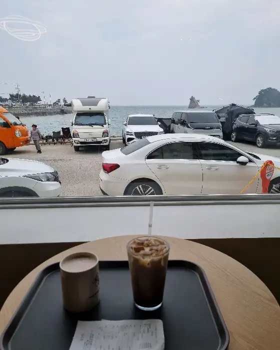 창밖으로 보이는 바다와 차량들의 모습