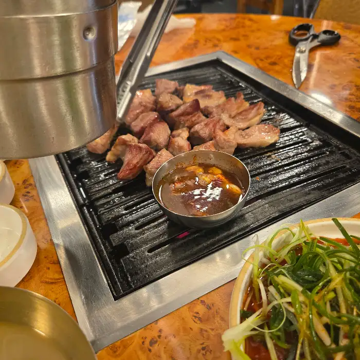 숯불 위에서 맛있게 구워지고 있는 흑돼지 조각들