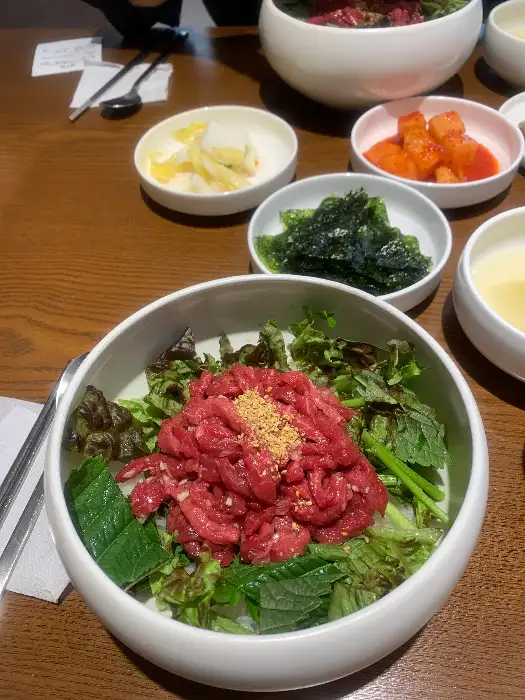 육회비빔밥에 신선한 채소와 육회가 듬뿍 올라간 모습