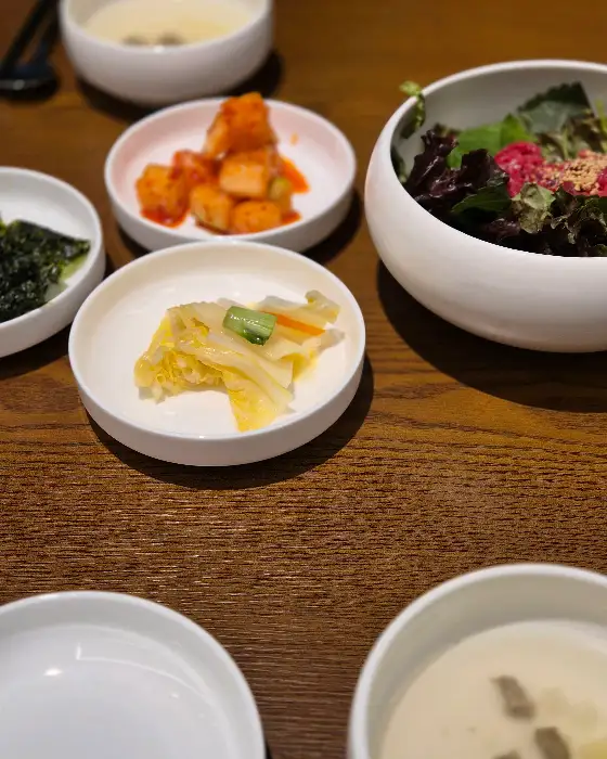 테이블에 차려진 다양한 밑반찬과 샐러드