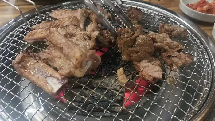 집게로 집어 올린 노릇하게 구워진 갈비