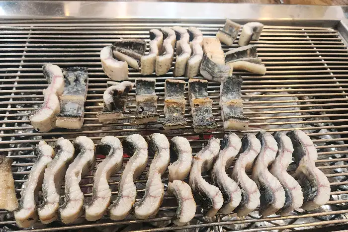 잘 구워져서 그릴 위에 가지런히 놓인 장어 조각들
