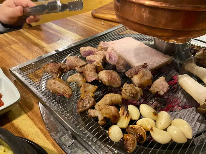 참숯 위에 구워지는 돼지고기와 마늘