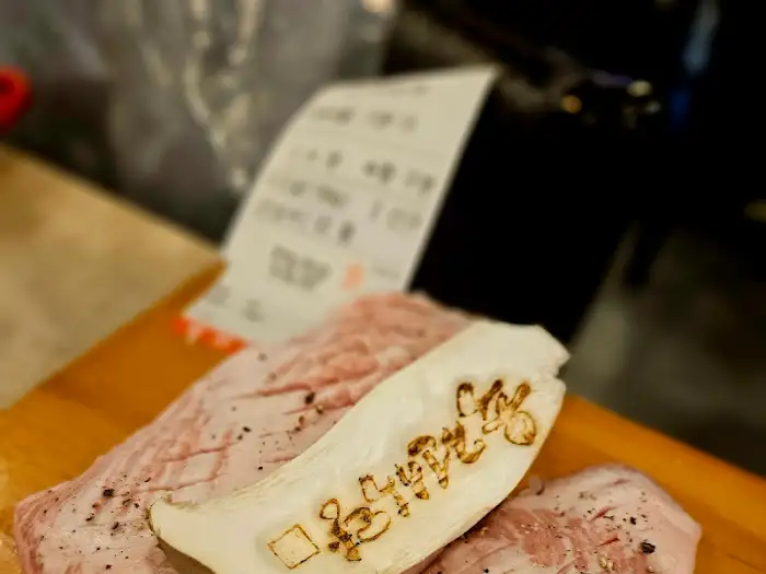 구워진 삼겹살 조각과 함께 버섯이 불판 위에 놓여 있습니다.