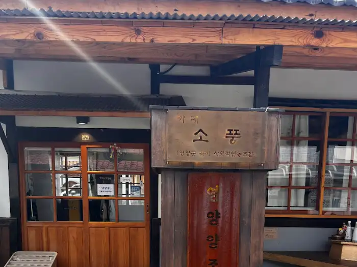 '소품' 카페의 이름이 새겨진 나무 간판. 세월의 흔적이 느껴지는 글씨체가 인상적입니다.