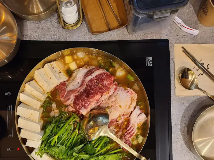 전골 냄비에 담긴 고기, 두부, 채소