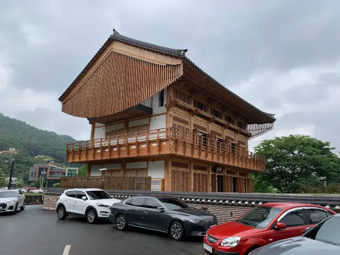 청주 한옥 서재 카페 외관 (산과 나무를 배경으로 한 웅장한 건물)