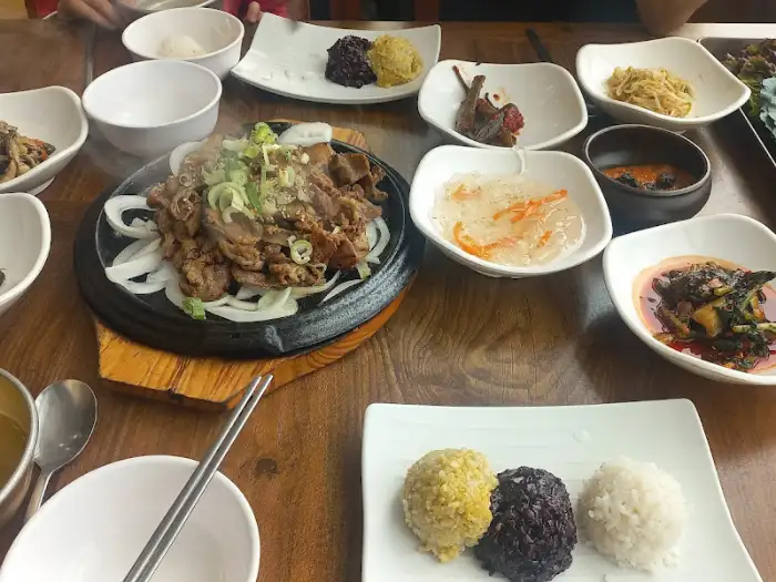 불고기, 쌈 채소, 여러 반찬이 차려진 식탁