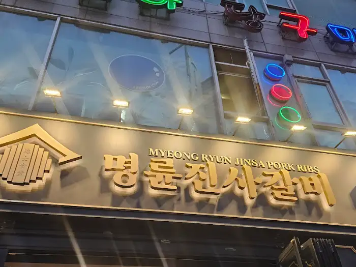 밤에 불빛이 켜진 명륜진사갈비 간판의 모습.