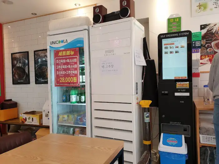 매장 내부의 주문 키오스크와 냉장고, 여러 음식 사진이 걸려 있다.