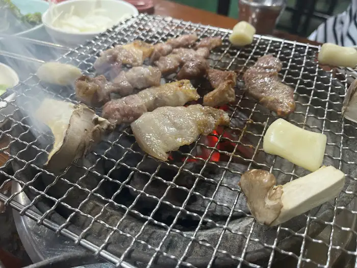 불판 위에서 삼겹살과 목살이 익어가며 맛있는 냄새를 풍기고 있다.