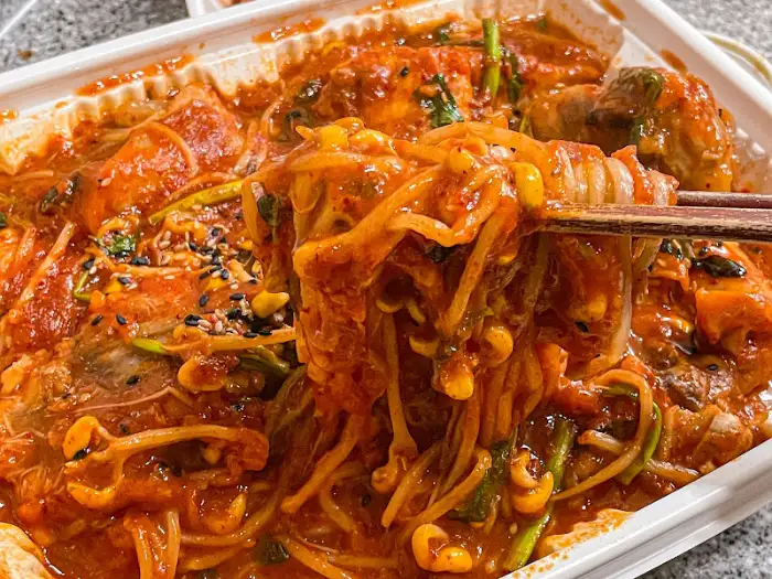 집게로 아구찜을 집어 올리는 모습. 콩나물과 함께 풍성하게 집힌다.