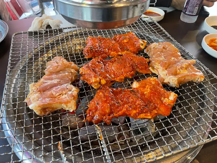 다양한 닭갈비 조각이 불판 위에서 익어가는 모습