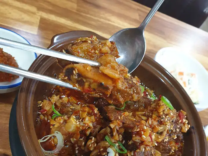 집게와 숟가락으로 집어 올린 소갈비찜