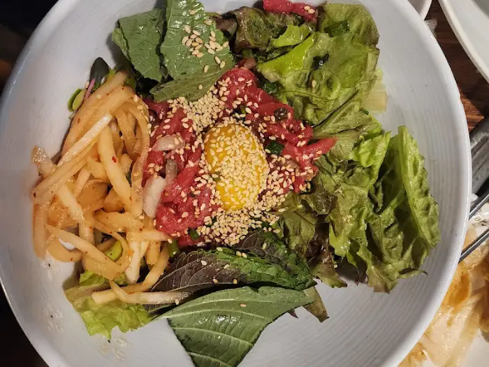 신선한 육회와 다양한 채소가 보기 좋게 담긴 육회 비빔밥