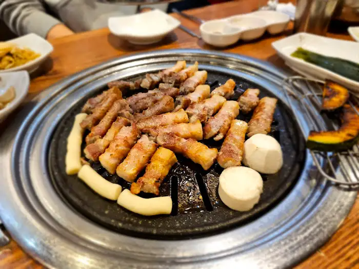 불판 위에서 고기와 떡, 호박 등이 익어가고 있는 모습