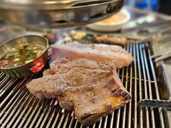 잘 익은 목살과 삼겹살이 불판 위에서 지글거리는 모습